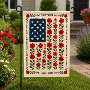 May include: A garden flag with a cream background features a blue rectangle with white stars, and rows of red flowers. The flag has the text "FUCK TRUMP" in a repeating pattern around the edges.
