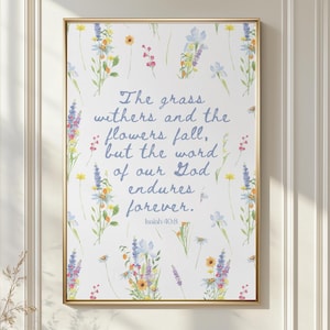May include: A rectangular wall art print in a gold frame featuring a white background with scattered watercolor wildflowers in shades of blue, yellow, and pink. The text reads: The grass withers and the flowers fall, but the word of our God endures forever. Isaiah 40:8.