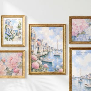 May include: A gallery wall set of five framed art prints featuring watercolour-style coastal scenes and floral arrangements. The collection includes images of houses by the water, sailboats, and pink hydrangea blossoms, all encased in matching gold frames.