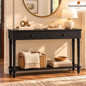 May include: A black console table with two drawers and four turned legs, featuring a lower shelf holding a woven basket with a white knit throw and a stack of books topped with a wooden bowl. The top surface holds a lamp and decor.