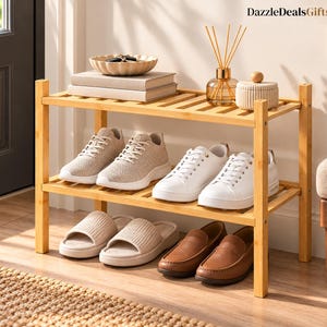 May include: A two-tier bamboo shoe rack holding various footwear including beige knit sneakers, white leather sneakers, beige slide sandals, and brown leather loafers. The top shelf features a small bowl, books, and a glass reed diffuser.