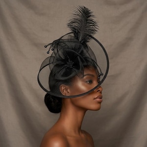 May include: A black fascinator hat featuring a large, layered mesh flower, a tall upright feather plume, and thin wire accents tipped with small black beads. The structure is circular, crafted from sheer black netting, and sits atop the head.