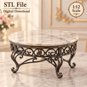 May include: A 1:12 scale digital download STL file for a round table with a white and beige faux marble top and a dark bronze-colored metal base featuring ornate scrollwork and four curved legs. The text STL File, Digital Download, and 1:12 Scale appear.
