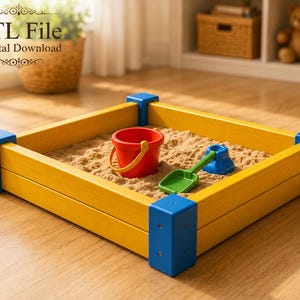Könnte beinhalten: Ein quadratischer Sandkasten mit gelben Holzseiten und blauen Eckverbindungen, gefüllt mit Sand. Im Sandkasten befinden sich ein roter Eimer mit gelbem Henkel, eine grüne Schaufel und eine blaue Sandform. Der Text STL File Digital Download ist sichtbar.