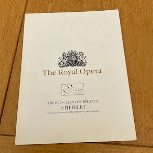 May include: A cream-colored flyer with gold text and a crest for The Royal Opera. The flyer promotes "The Big Screen Live Relay of Stiffelio" from the Verdi Festival, sponsored by The Friends of Covent Garden.