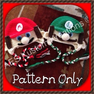 May include: Two crocheted hats, one red and one green, with white yarn and brown details. The hats are shaped like the characters Mario and Luigi from the video game Super Mario Bros. The hats have long, crocheted ties. The text "Pattern Only" is written below the hats.