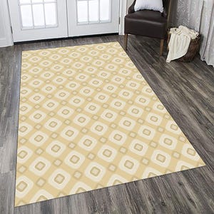 May include: A rectangular area rug featuring a repeating geometric pattern of rounded squares in shades of cream, beige, and light tan. The design consists of nested square shapes with soft, curved corners arranged in a consistent grid layout.