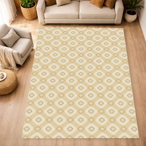 May include: A rectangular area rug featuring a repeating geometric pattern of rounded squares in shades of beige, cream, and light tan. The design consists of concentric square shapes with soft, curved corners arranged in a grid across the surface.