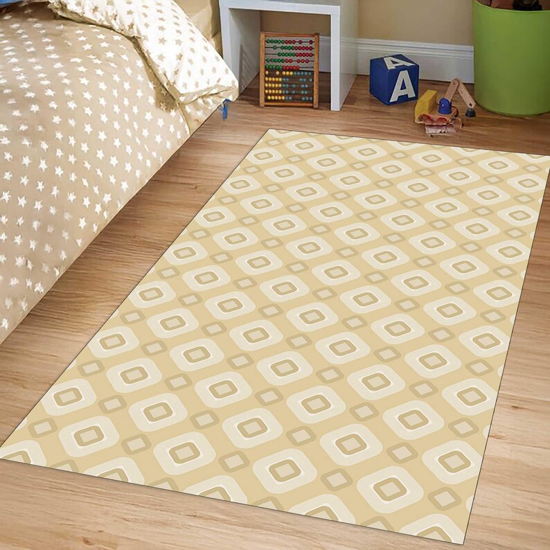 May include: A rectangular area rug featuring a repeating geometric pattern of light beige and cream-coloured rounded squares arranged in a grid. The rug lies flat on a wooden floor, showcasing a consistent, symmetrical design across its entire surface.