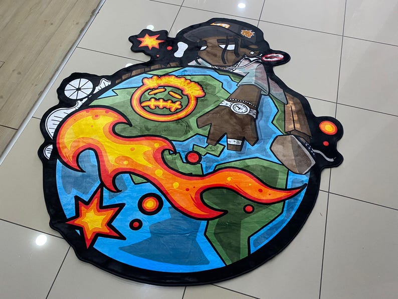 May include: A round, cartoon-style rug featuring a character on a globe with flames and stars. The rug has a black border and a colorful design with shades of blue, green, orange, and brown. The character is wearing a hat and watch.