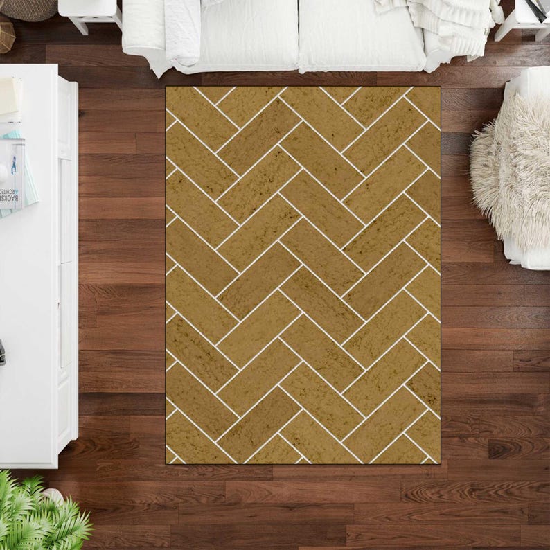 May include: A rectangular area rug featuring a repeating herringbone pattern. The rug consists of golden-brown, textured rectangular segments separated by thin, crisp white lines, creating a structured geometric design across the entire surface.