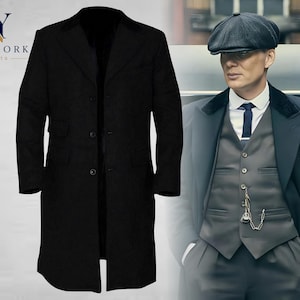Puede incluir: Un abrigo largo negro con cierre de tres botones. El abrigo se muestra junto a una persona que lleva un traje oscuro, chaleco, corbata y una gorra plana. El texto "NY NEW YORK JACKETS" está en la esquina superior izquierda.