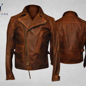 Pode incluir: Casaco de couro castanho com fecho de correr assimétrico, gola entalhada e vários bolsos. O casaco apresenta um acabamento envelhecido e um detalhe de cinto na cintura. O logótipo "NY NEW YORK JACKETS" é visível no canto superior esquerdo.