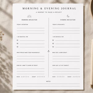 May include: A white paper journal page titled Morning & Evening Journal: A Moment to Pause & Reflect. The layout is split into two columns for Morning Reflection and Evening Reflection, featuring lines for writing, gratitude lists, and mood trackers.