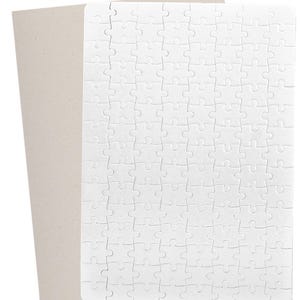 May include: A white blank jigsaw puzzle with interlocking pieces, ready for customization. The puzzle is rectangular and sits on a light brown cardboard backing, perfect for a personalized gift or activity.