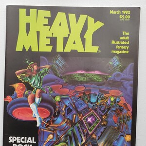 May include: A magazine cover for Heavy Metal, an adult illustrated fantasy magazine. The cover features a woman in a green outfit sitting on a futuristic vehicle. The cover text reads "Heavy Metal" and "The adult illustrated fantasy magazine".