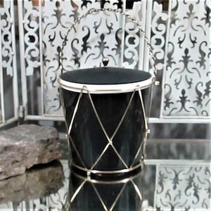 May include: A black and white ice bucket with a silver wire handle and a black lid. The bucket has a diamond pattern on the side.
