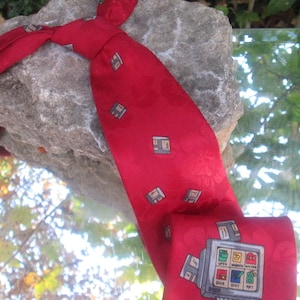 Puede incluir: Una corbata de seda roja con un patrón de disquetes y una pantalla de ordenador con las palabras "Open", "Window", "Save", "Exit" y "About".