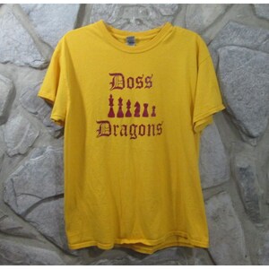 May include: Yellow t-shirt with a burgundy graphic of chess pieces and the text "Doss Dragons" in a gothic font.