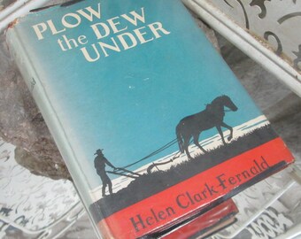 Könnte beinhalten: Ein Vintage-Hardcover-Buch mit dem Titel "Plow the Dew Under" von Helen Clark Fernald. Der Umschlag zeigt einen blauen Hintergrund mit einer Silhouette eines Bauern, der mit einem Pferd ein Feld pflügt.