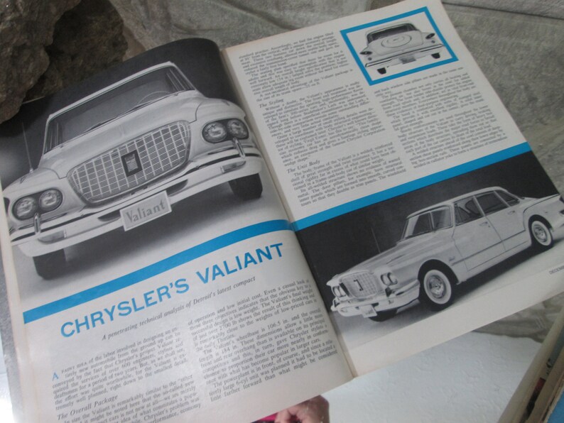 May include: A magazine spread featuring a black and white photo of a 1960s Chrysler Valiant car. The magazine article discusses the technical aspects of the car, including its design, engine, and performance. The text on the page reads "Chrysler's Valiant: A penetrating technical analysis of Detroit's latest compact."