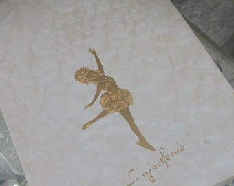 Könnte beinhalten: Eine weiße Karte mit einem goldenen Bild einer Ballerina in einem Tutu. Die Karte ist signiert mit "Sonja Henie".