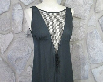 Könnte beinhalten: Ein schwarzes, ärmelloses Kleid mit einem durchsichtigen Netzpanel am Ausschnitt. Das Kleid hat einen V-Ausschnitt und ein tailliertes Oberteil.