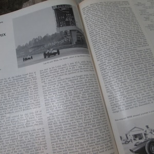 May include: A black and white photo of a vintage race car speeding around a track. The car is in the lead and is about to pass another car. The photo is taken from a high angle and shows the car's speed and power.