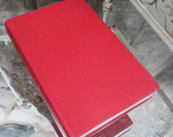 Op de afbeelding: Een rood hardback boek met een witte rand rond de randen.