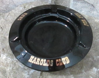 Könnte beinhalten: Schwarzer Aschenbecher aus Glas mit goldener Aufschrift "Harold's Club" und "Just For Fun".