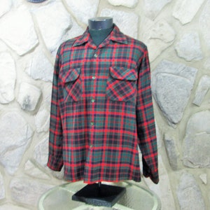 Puede incluir: Una camisa de manga larga a cuadros con cuello abotonado. La camisa es roja, verde y negra.