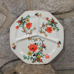 Può includere: Un piatto da portata ottagonale bianco diviso con un motivo floreale. Il piatto ha tre sezioni e presenta fiori rossi, gialli, verdi e blu.