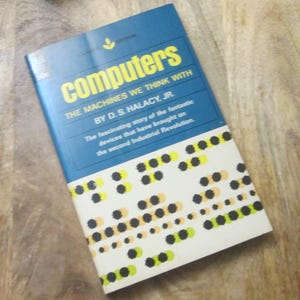 May include: A retro book cover for "Computers" in blue with yellow text. The title is prominent, with the subtitle "THE MACHINES WE THINK WITH" and the author's name. The cover design includes a pattern of black, yellow, and orange dots.