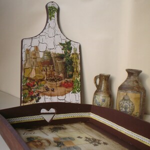 May include: A decorative wooden serving tray and cutting board with a rustic, crackled finish. The tray features a heart-shaped cutout and a decorative border. The cutting board and tray are decorated with images of olives, bottles, and herbs.