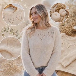 May include: A cream-coloured long-sleeve jumper featuring a round neckline and a delicate openwork heart pattern across the yoke. The knit garment has a soft texture, long sleeves, and a ribbed collar, cuffs, and hem, showcasing a consistent design.