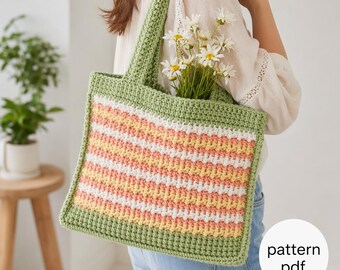 May include: A crocheted tote bag with a striped pattern in pastel colors of peach, yellow, and white, framed by a green border and handles. The bag is filled with white flowers. The text "pattern pdf" is in the lower right corner.