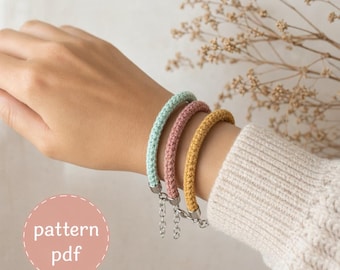 May include: Three colorful bracelets in pastel shades of mint green, dusty rose, and mustard yellow. Each bracelet is made of a woven material and has a silver-colored chain clasp. The image also includes the text "pattern pdf".