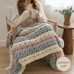 May include: A handmade crochet blanket in pastel colors of pink, blue, green, and cream. The blanket is draped over a chair. The image includes the text "pattern pdf".