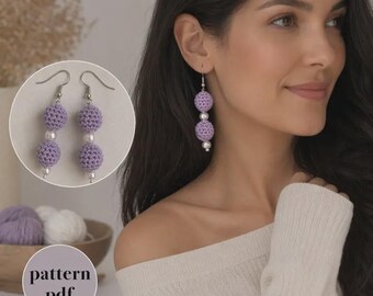 May include: Dangle earrings featuring two lavender crocheted spheres separated by small white beads, suspended from silver-toned hooks. The design includes a circular inset showing the pair of earrings and a text label reading pattern pdf.