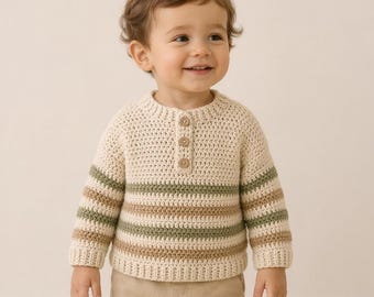May include: A cream-colored, crocheted sweater with three wooden buttons at the neckline. The sweater features horizontal stripes in shades of green and brown on the sleeves. The sweater is designed for a child.