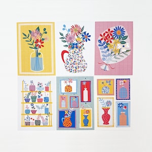 May include: A selection of vibrant floral art prints. The prints showcase vases and bouquets filled with flowers, set against backgrounds of yellow, pink, and blue. Some prints depict a shelf with potted plants. The art style is bright and cheerful.