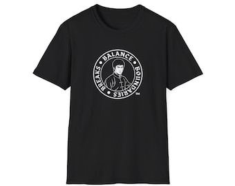 Könnte beinhalten: Ein schwarzes Kurzarm-T-Shirt mit einer weißen kreisförmigen Grafik auf der Brust. Die Grafik zeigt ein Porträt von Bruce Lee, umgeben von dem Text "BALANCE" und "BREAKS BOUNDARIES" mit einem Markenzeichen-Symbol unten rechts.