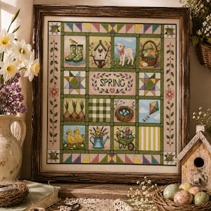 May include: A framed cross-stitch sampler featuring a grid of twelve seasonal squares, including a lamb, chicks, a birdhouse, and a basket of eggs. The center square displays the word SPRING surrounded by floral vines and a heart in a quilt-like pattern.