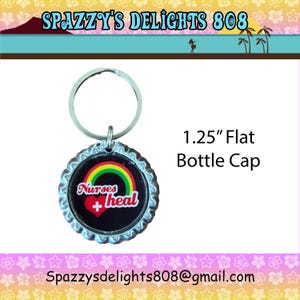 May include: A 1.25-inch flat bottle cap keychain featuring a black background with a colorful rainbow graphic above a red heart containing a white medical cross. The text Nurses heal is printed in white script lettering across the center.