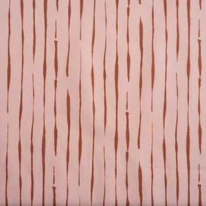 May include: A pink fabric with a repeating pattern of brown vertical lines. The lines are slightly wavy and have a hand-painted look.