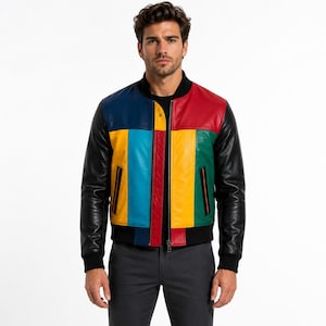 Op de afbeelding: Een bomberjack met kleurvlakken, zwarte mouwen en een veelkleurig voorpand met secties in marineblauw, lichtblauw, rood, geel en groen. Het jack is voorzien van een zwarte geribbelde kraag, boorden, een zoom en een centrale zilveren ritssluiting.