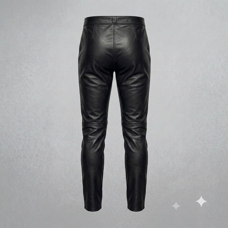 Puede incluir: Un pantal&oacute;n de cuero negro con acabado liso, cintura estructurada y costuras horizontales en la zona de las rodillas. El pantal&oacute;n tiene una silueta ajustada con una costura vertical central que recorre la parte posterior de las piernas.