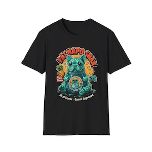 Pode incluir: Uma t-shirt preta de manga curta com um gráfico de um bulldog francês azul-petróleo dentro de um frasco de vidro. O texto diz FAT NAPO SNAX, Viral Flavor e Gamer Approved. Um ananás, snacks e um comando de jogo também estão ilustrados.