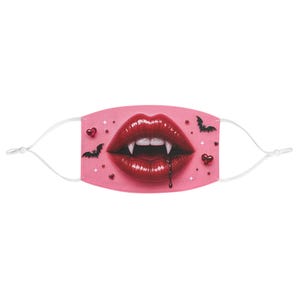 May include: A pink face mask featuring a close-up of red lips with vampire fangs and a drop of blood. The mask is decorated with small hearts, stars, and bat silhouettes. White adjustable ear loops are attached.