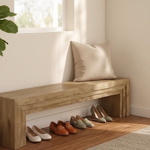 May include: A wooden bench with a light brown finish, a beige pillow, and several pairs of shoes. The shoes include flats, loafers, and heels in various colors, such as white, brown, and green.